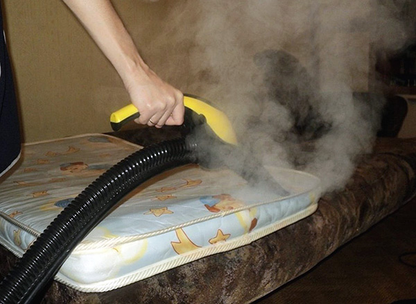 The photo shows an example of processing the mattress with hot steam in order to destroy bedbugs and their eggs.