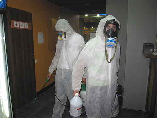 A képen a fertőtlenítő szakemberek látják el a helyiség kezelését.